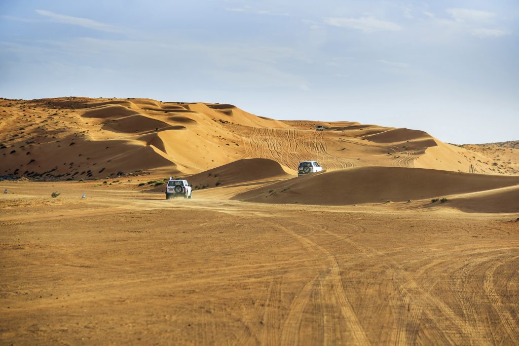 Vehicles driving in Wahiba sands desert, Oman